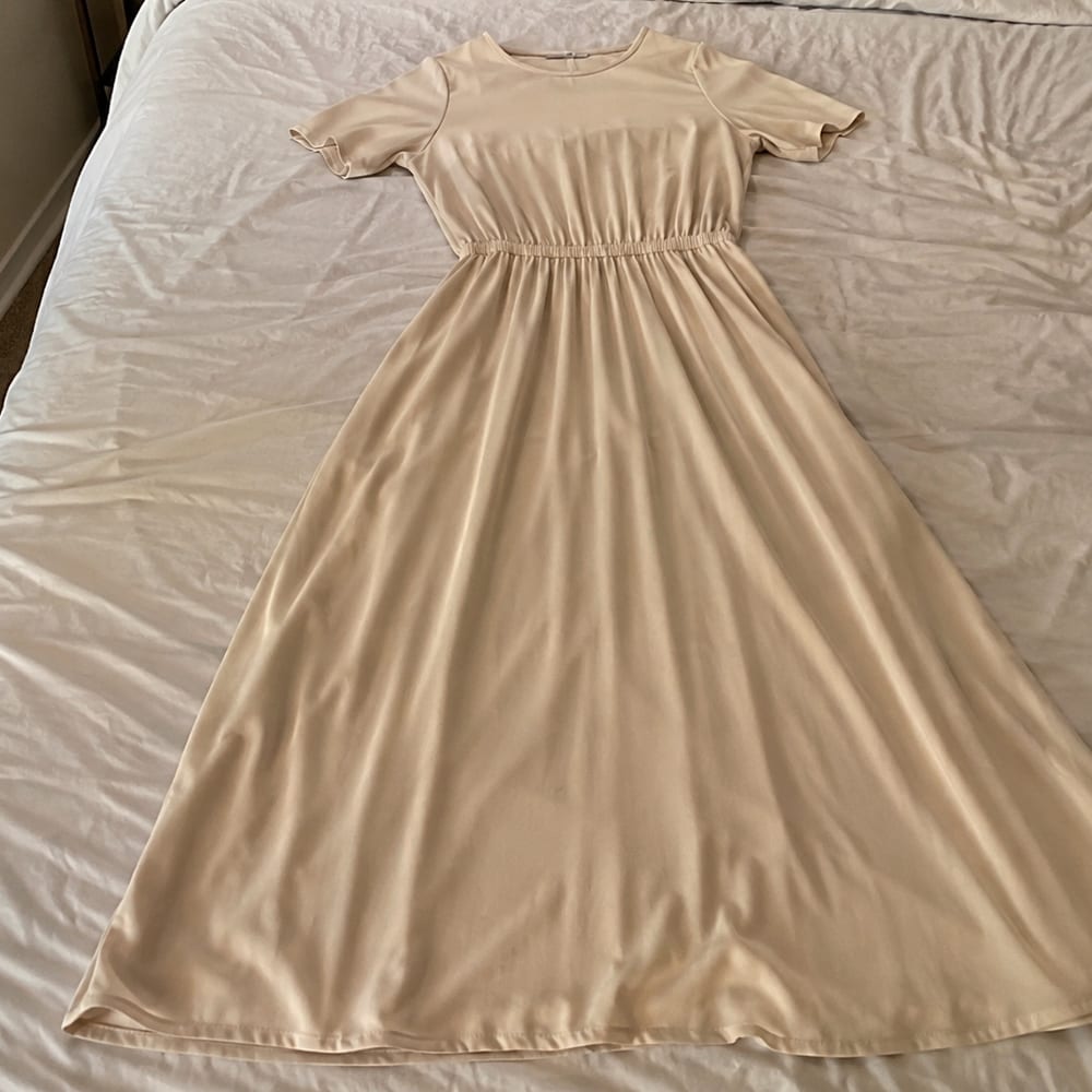 Foto del producto sin optimizar: vestido sobre una cama con fondo arrugado